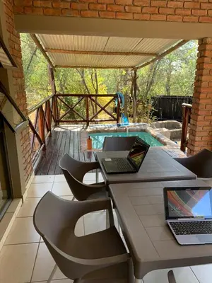 a patio with a table with two laptops on it at Umhlanga Kruger in Marloth Park