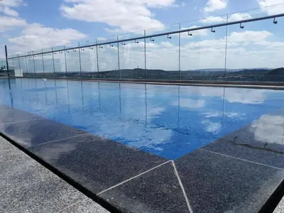 a reflection of a bridge in a pool of water at Menlyn Apartment in Pretoria