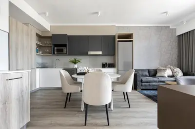 a kitchen and living room with a table and chairs at Menlyn Apartment in Pretoria