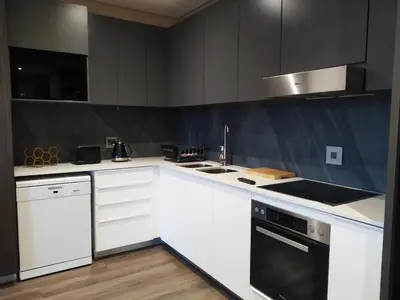 a kitchen with white cabinets and a stove top oven at Menlyn Apartment in Pretoria