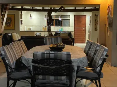 a dining room table with chairs and a bowl of fruit on it at Twiga Lodge Mabalingwe in Bela-Bela