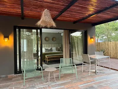 a patio with chairs and a table and a bed at Together Lifestyle Resort in Malamulele