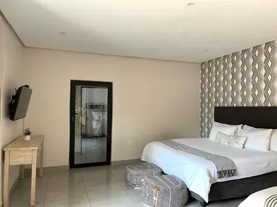 a bedroom with a large bed and a television at Together Lifestyle Resort in Malamulele