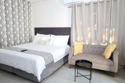 a bedroom with a bed and a chair at Together Lifestyle Resort in Malamulele