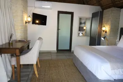 a bedroom with a bed and a desk with a computer at Together Lifestyle Resort in Malamulele