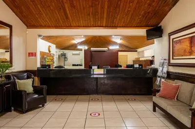 a lobby with a reception desk and chairs at ATKV Eiland Spa in Letsitele