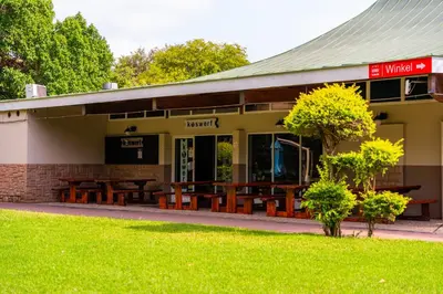 a building with picnic tables in front of it at ATKV Eiland Spa in Letsitele