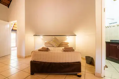 a bedroom with a bed with towels on it at ATKV Eiland Spa in Letsitele