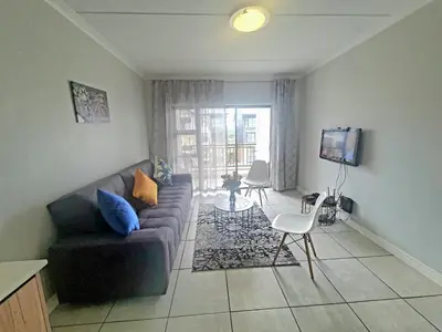 a living room with a couch and a tv at The Blyde Crystal Lagoon in Pretoria