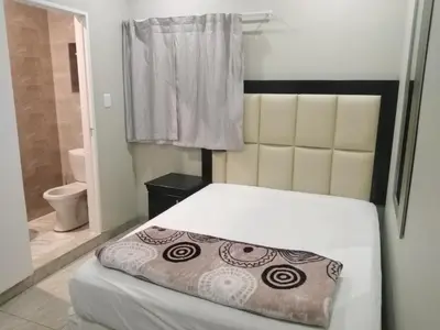 a bedroom with a bed and a bathroom with a toilet at Classic-Lodge in Kempton Park