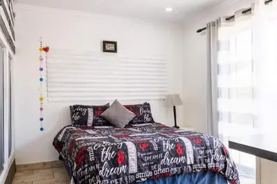 a bedroom with a bed with a comforter and pillows at MyKhaya-your home away from home in Kempton Park