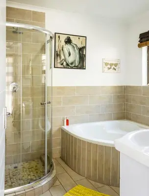 a bathroom with a shower and a tub and a sink at MyKhaya-your home away from home in Kempton Park