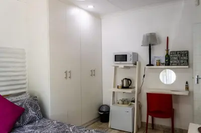 a small room with a bed and a microwave at MyKhaya-your home away from home in Kempton Park