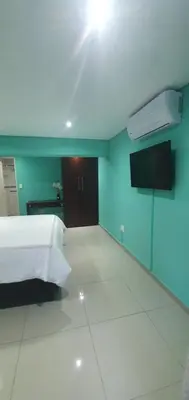 a bedroom with a white bed and a blue wall at Tertius Lodge And House in Nelspruit
