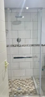 a shower with a glass door in a bathroom at Tertius Lodge And House in Nelspruit