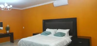 a bedroom with a bed with two pillows on it at Tertius Lodge And House in Nelspruit