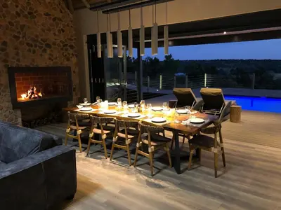 a dining room with a table and a fireplace at Hillside lodge in Moheme