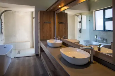 a bathroom with two sinks and two bowls on a counter at Hillside lodge in Moheme
