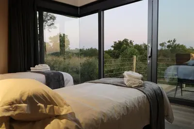 a bedroom with two beds and a large window at Hillside lodge in Moheme