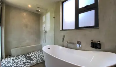 a bath tub in a bathroom with a window at Hillside lodge in Moheme