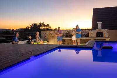 a group of people standing around a swimming pool at Hillside lodge in Moheme