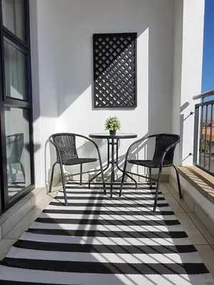 a patio with two chairs and a table on a balcony at The Blyde - Appartement De Luxe in Pretoria
