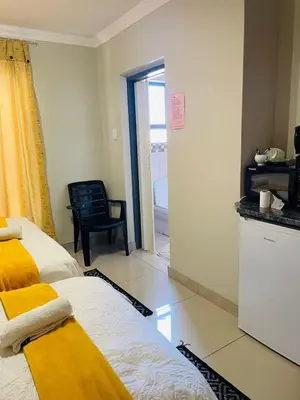 a bedroom with a bed and a chair in a room at ONNIE GUESTHOUSE in Louis Trichardt