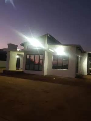 a house with lights on the side of it at night at ONNIE GUESTHOUSE in Louis Trichardt