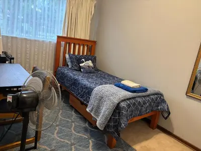 a bedroom with a bed and a fan at Bottie's Rock in Pretoria