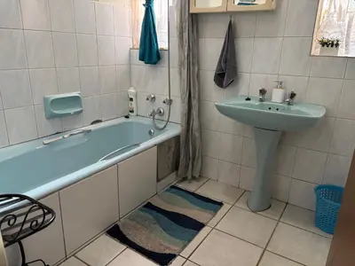 a bathroom with a bath tub and a sink at Bottie's Rock in Pretoria