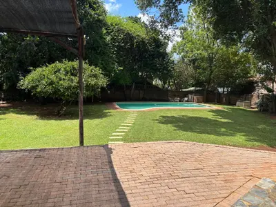 a brick patio with a swimming pool in a yard at Bottie's Rock in Pretoria