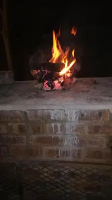 a large fire in a brick oven with flames at Bottie's Rock in Pretoria