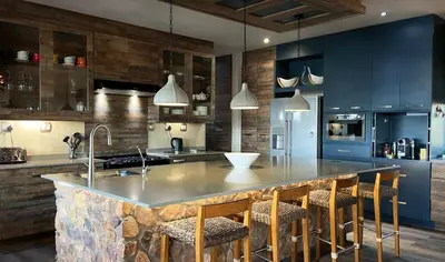 a kitchen with blue cabinets and a large island with bar chairs at Shammah lodge Mabalingwe Nature Reserve in Mabula