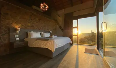 a bedroom with a bed and a large window at Shammah lodge Mabalingwe Nature Reserve in Mabula
