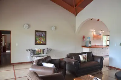 a living room with leather furniture and an archway at Muqurati Lodge - Dinokeng Game Reserve in Klipdrift