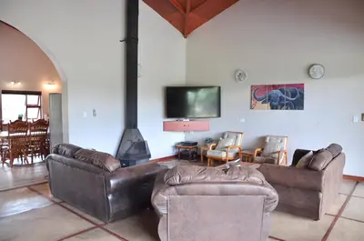 a living room with leather couches and a fireplace at Muqurati Lodge - Dinokeng Game Reserve in Klipdrift