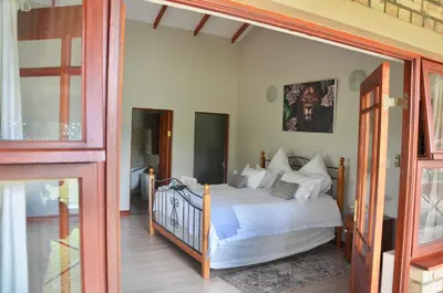 a bedroom with a bed and a glass door at Muqurati Lodge - Dinokeng Game Reserve in Klipdrift