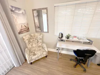 a living room with a chair and a desk at Buffels Place Guesthouse in Pretoria