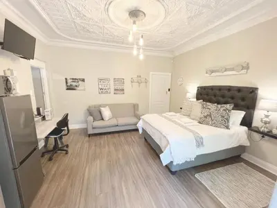 a bedroom with a bed and a desk and a chair at Buffels Place Guesthouse in Pretoria