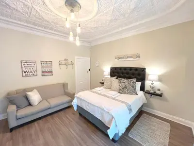 a bedroom with a bed and a couch at Buffels Place Guesthouse in Pretoria