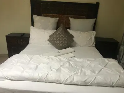 a white bed with white sheets and pillows at Kaste Guesthouse Secunda in Secunda