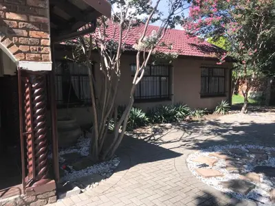 a house with a tree in front of it at Kaste Guesthouse Secunda in Secunda