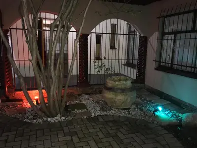 a room with a potted plant and a building at Kaste Guesthouse Secunda in Secunda