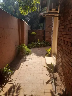 an alley with a brick wall and a brick sidewalk at Hazelonz Bed &Breakfast in Pretoria