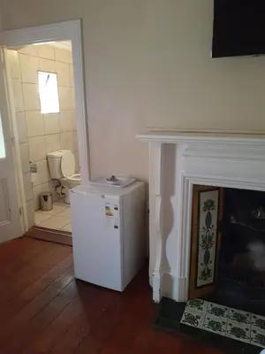 a white refrigerator in a room with a fireplace at Hazelonz Bed &Breakfast in Pretoria