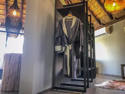 a robe hanging on a rack in a room at Laluka Safari Lodge - Welgevonden Game Reserve in Welgevonden Game Reserve