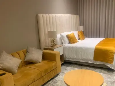 a hotel room with a bed and a couch at Menlyn Maine Luxury Apartments in Pretoria