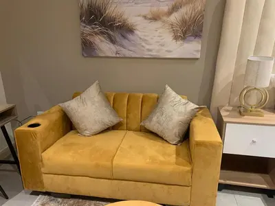 a yellow leather couch in a living room at Menlyn Maine Luxury Apartments in Pretoria
