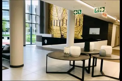 a lobby with two tables and chairs in a building at Menlyn Maine Luxury Apartments in Pretoria
