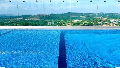 a swimming pool with blue water and a view of a city at Menlyn Maine Luxury Apartments in Pretoria